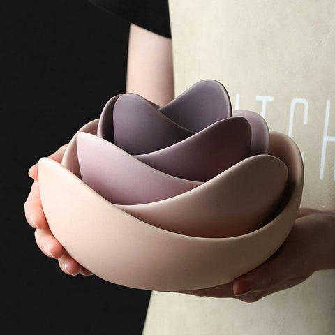 Stacked lotus bowls in rose held in one hand