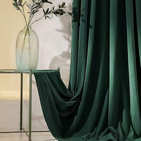 Dark green velvet blackout curtain, draped to show the fabric