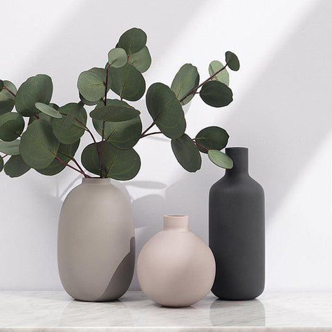 Three neutral Scandi ceramic vases holding eucalyptus stems