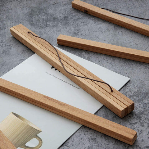 Wooden poster hanger rails with leather hanging cord and a rolled print