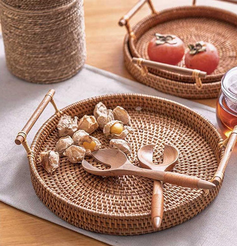 Rattan storage trays holding nuts and a candle on a worktop