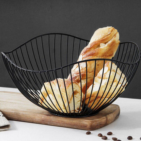 Black wire fruit basket holding bread on a wooden board