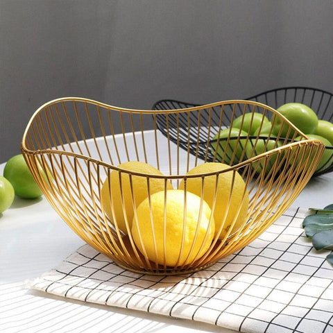 Gold wire fruit basket holding fruit on a chequered tea towel