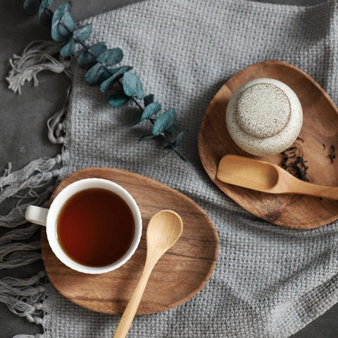 Wooden tray with a cup of tea and a honey spoon